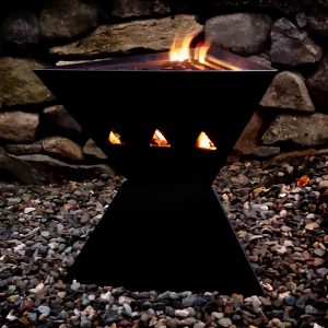 Lit TetraFlame pack away portable fire pit at night with barbecue cooking grill