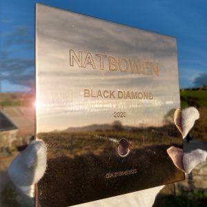 Completed bronze gallery plaque etched with "Nat Bowen Black Diamond 2020" and setting for the diamond below reflecting the evening sun and the Llyn Peninsula