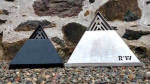 A black TetraFlame Pack Away Fire Pit BBQ and a TetraFlameXL Pack Away Fire Pit BBQ packed away inside themselves ready for storage