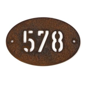 Modern oval metal house number in rusted industrial look Corten weathering steel