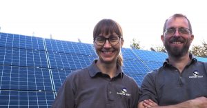 A smiling Jo and Nick of Ravens' Way with their solar photovoltaic panels