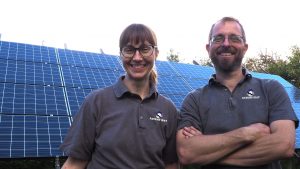 A smiling Jo and Nick of Ravens' Way with their solar photovoltaic panels