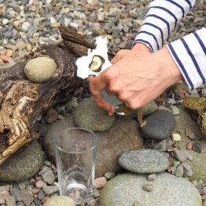Cymru Wales map metal bottle opener in stainless steel in use at the beach