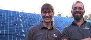 A smiling Jo and Nick of Ravens' Way with their solar photovoltaic panels