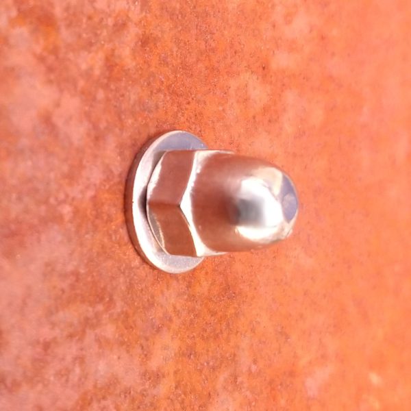 Closeup of stainless steel dome head sign fixing kit in use with COR-TEN weathering steel