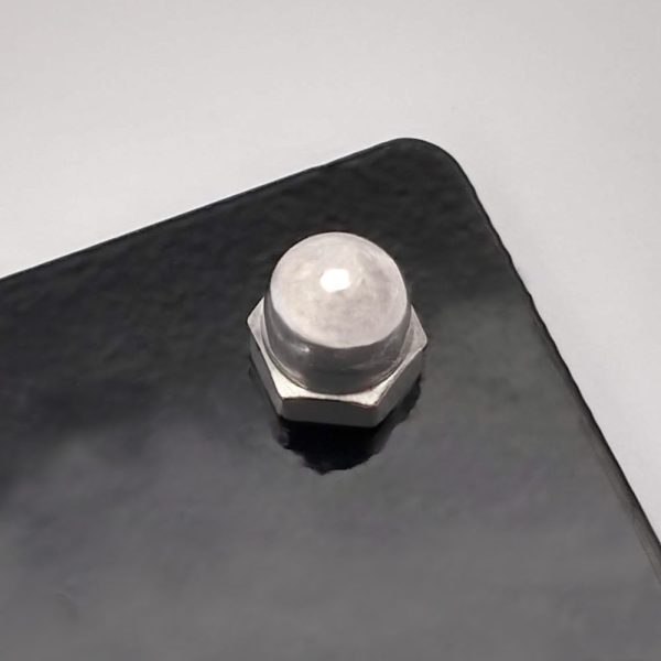 Metal sign fixing kit with standoff spacer in use on a black metal house sign