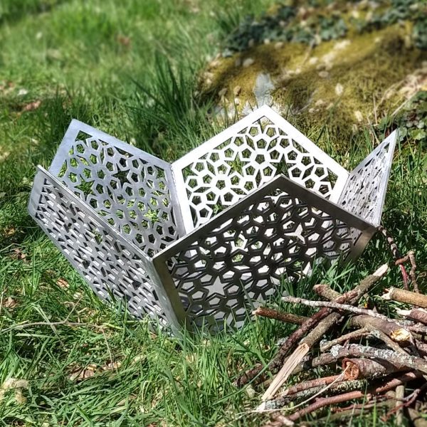 A silver bare steel Star of Morocco Fire Pit in our woodland