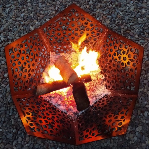 A lit black Star of Morocco Fire Pit BBQ and Ground Guard burning wood on a summer's evening