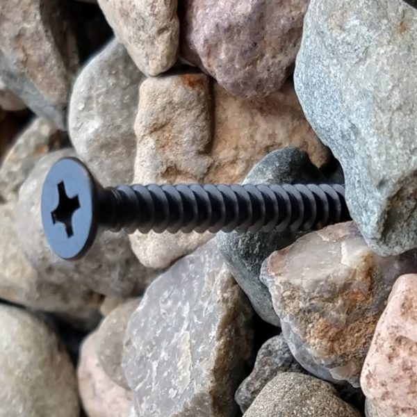 Black metal countersunk sign fixing kit with standoff spacers for masonry in use