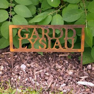 Vintage-look rusty metal two legged Gardd Lysiau vegetable garden sign in Welsh in our garden
