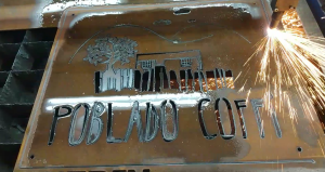 Poblado Coffi's COR-TEN weathering steel sign being cut on our CNC plasma cutter