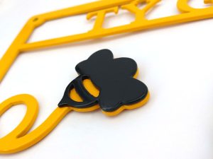 Closeup of two layer construction on multi-coloured metal house sign