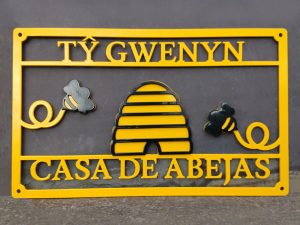 Completed multi-coloured bee-theme bilingual metal house sign