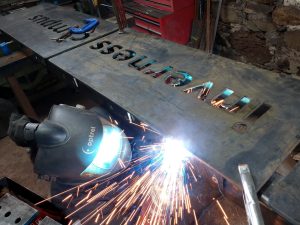 Welding the mounting lugs to the back of one monolith sign