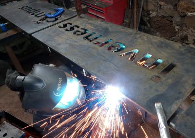 Welding the mounting lugs to the back of one monolith sign