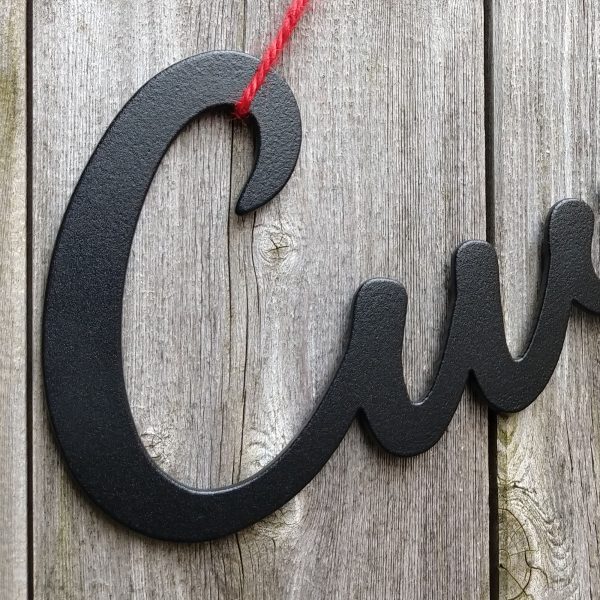 Closeup of Cwtch heartfelt Welsh hug black cast iron effect hanging metal sign