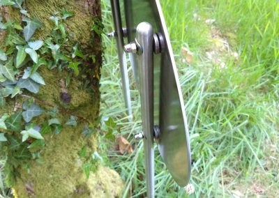 Closeup of the back of the sign showing the tubular stainless steel posts with solid end caps, fixings and hidden studs