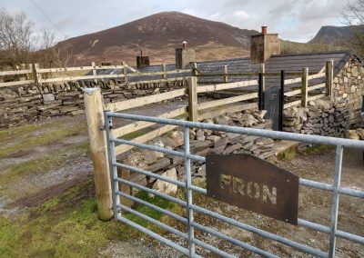 View of mountain-shaped CORTEN weathering steel house name sign, with gate and mountain in the background