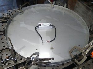 Fitting the sides and back lighting into one of the stainless steel clam shells