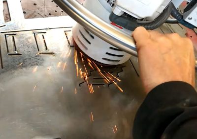 Deburring and edge rounding the front panel using a swing grinder