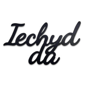 Iechyd da hanging black metal decorative "Cheers!" in Welsh sign on a white background.